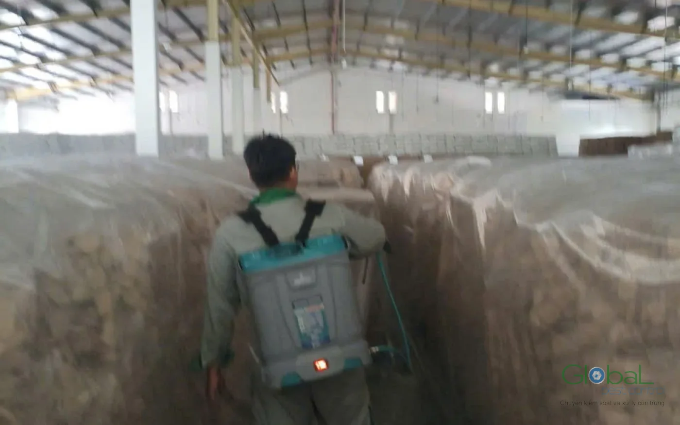 Kỹ thuật viên Khử Trùng Toàn Cầu xử lý khu vực kho nguyên liệu trong nhà xưởng